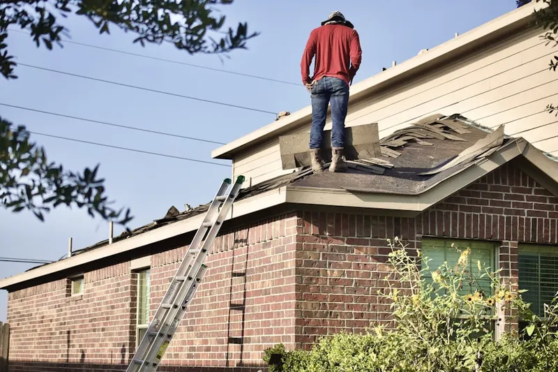 Professional roofer working on a residential roof in Camp Kiwanis